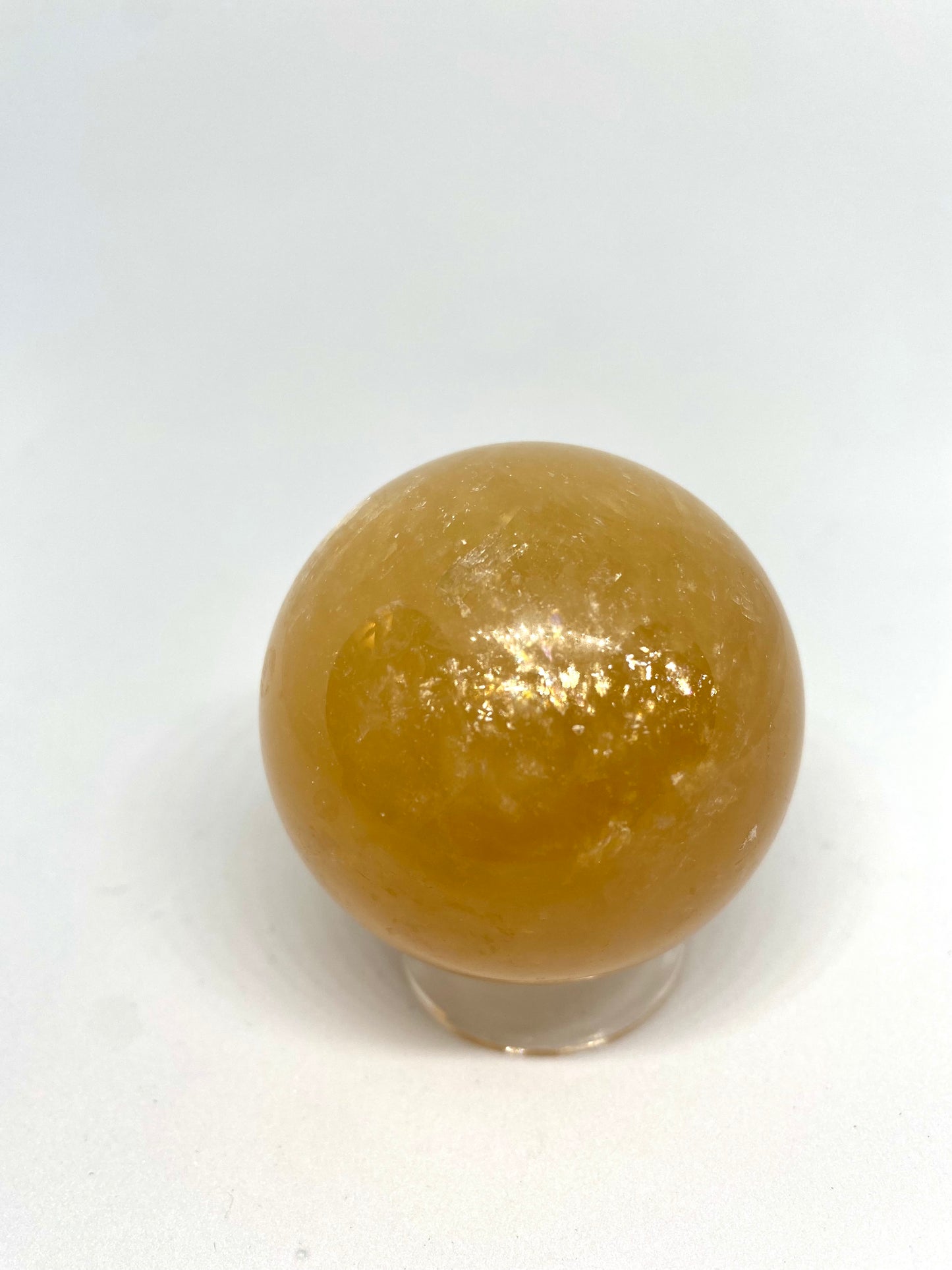 Honey calcite sphere with rainbows